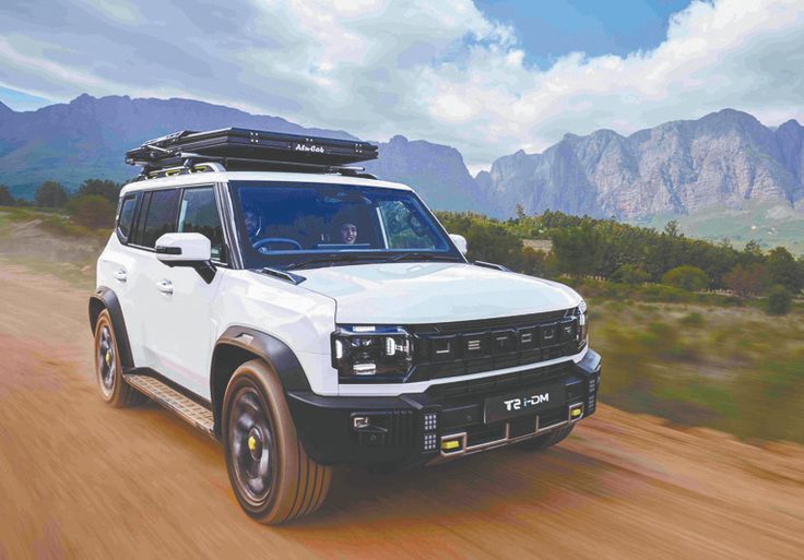 White SUV travelling through a mountain landscape