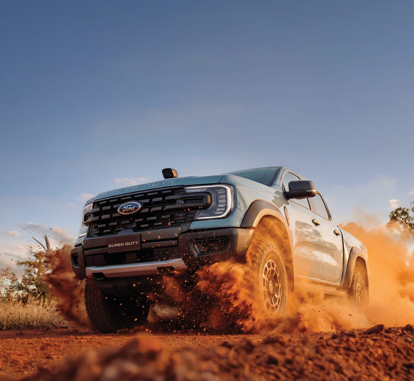 Ford Ranger kicking up red dust on an outback track