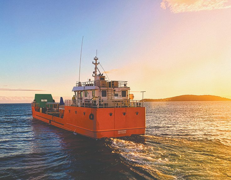 Commercial vessel at sea at sunset