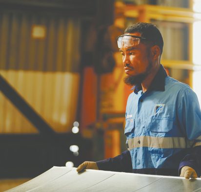 Daikin technician carrying ductwork in the workshop
