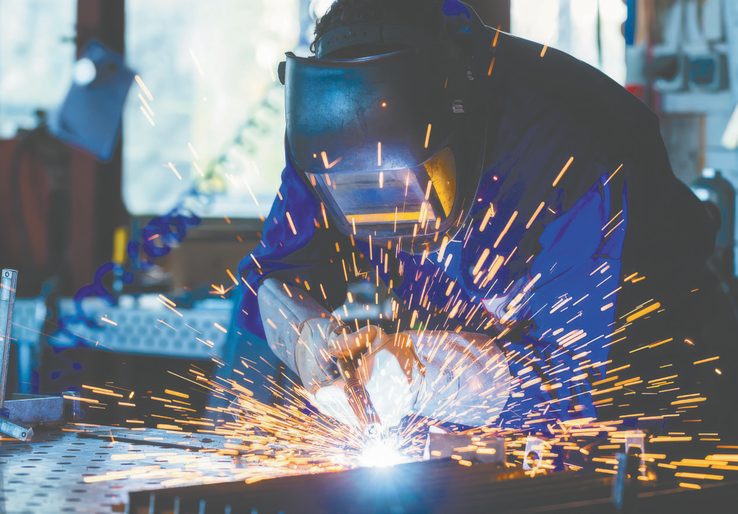 Welder fabricating structural steel, sparks flying